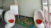 Zona infantil en el concesionario Driveris con alfombra de juegos y sillas colgantes