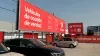 "Vista lateral del concesionario Driveris con coches estacionados y mensaje promocional".