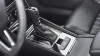 Interior de un coche moderno con detalle de la palanca de cambios de transmisión automática, resaltando el diseño sofisticado y la tecnología avanzada del vehículo.