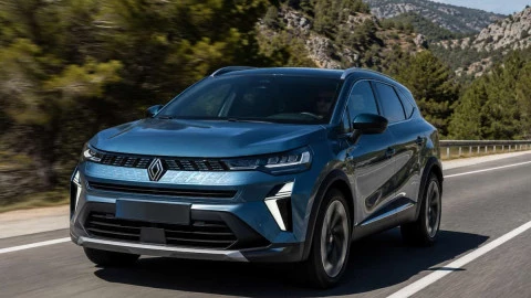 Renault Symbioz circulando por carretera con conductor al volante y diseño SUV híbrido moderno