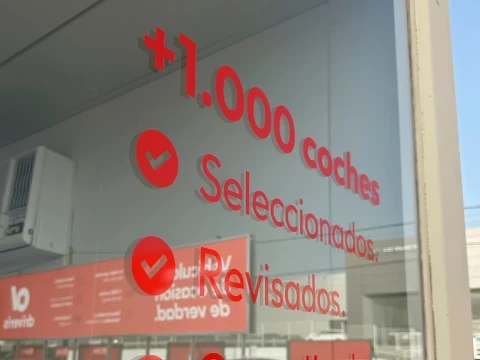 Ventanal del concesionario Driveris con mensaje promocional sobre vehículos seleccionados y revisados
