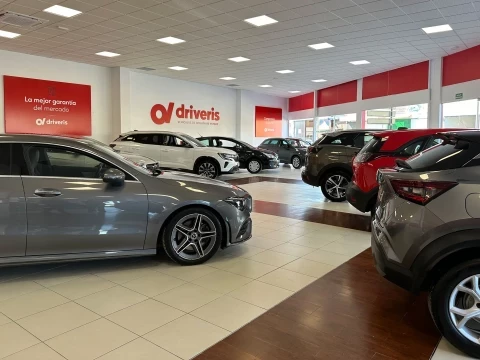 Interior del concesionario Driveris Córdoba con coches de ocasión en exposición.