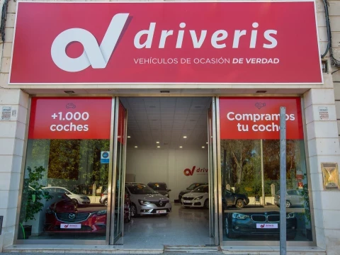 Fachada de Driveris Écija con acceso principal y mensaje "Compramos tu coche".