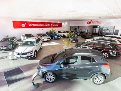 Interior de la sala de exposición en Driveris Trigueros con varios coches en exhibición.