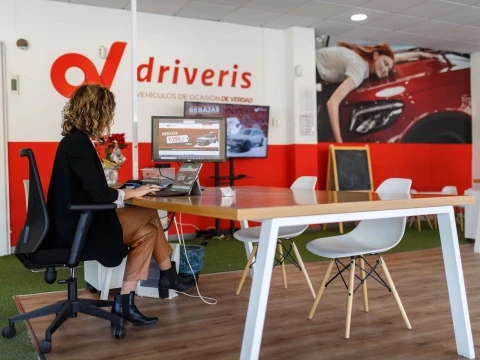 Oficina de atención al cliente en Driveris Almería con una asesora atendiendo a un cliente.
