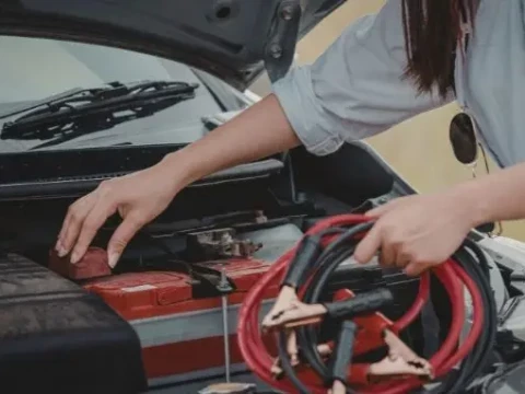Persona encendiendo el coche con pinzas