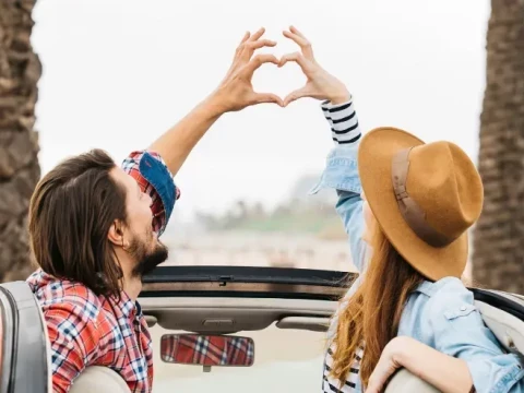 Pareja iniciando una ruta veraniega en su coche de segunda mano