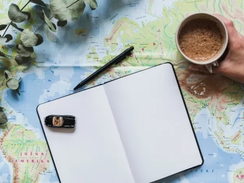 Mesa con una libreta y cafe para planificar el viaje