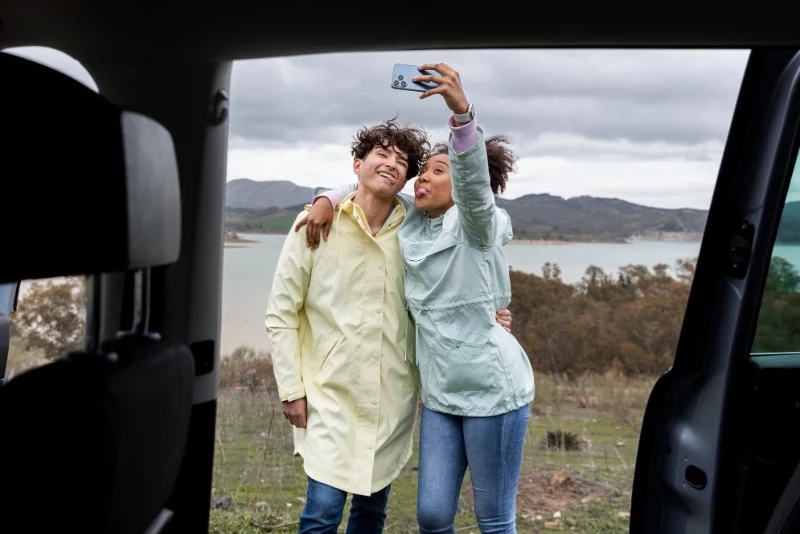 Pareja haciéndose una foto con su coche