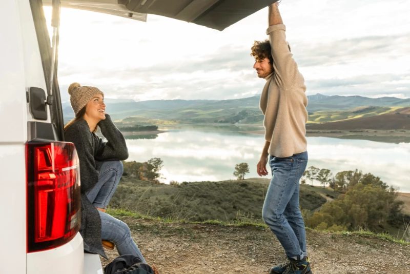 Pareja sentada en su furgoneta camper