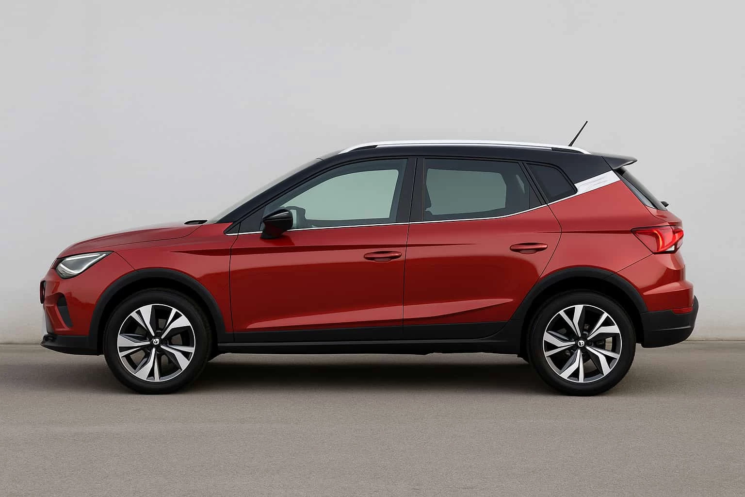 Vista lateral del SEAT Arona 2025 en color rojo sobre fondo gris claro