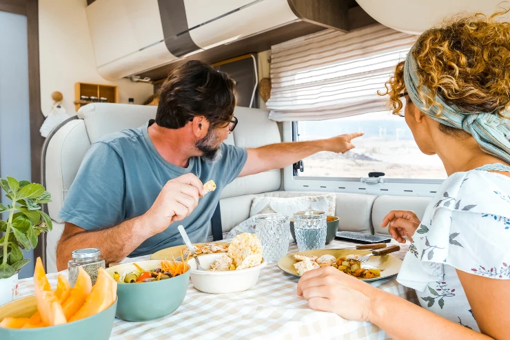 Pareja feliz desayunando en la autocaravaba