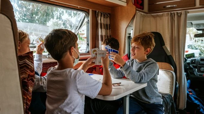 niños jugando a las cartas en su mesa de la autocaravana