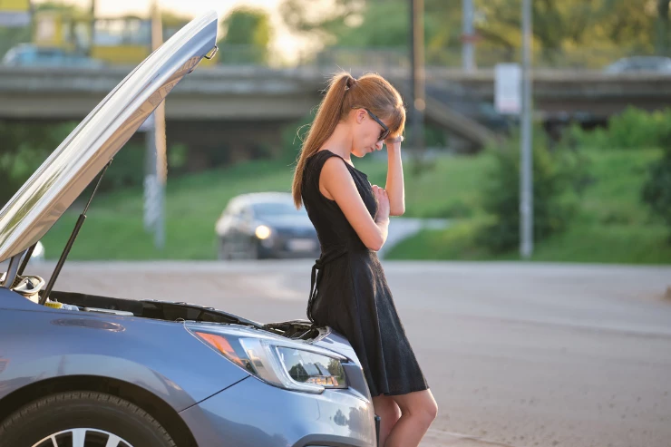 Mujer con el capo de su coche abierto estropeado
