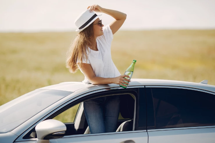 Mujer con botella de agua en coche