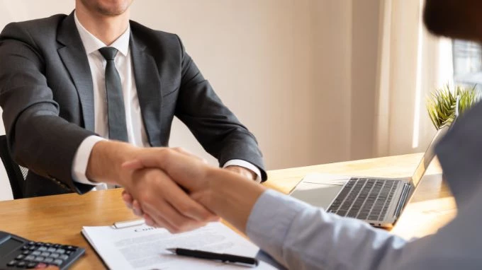 Personas dándose la mano en un concesionario