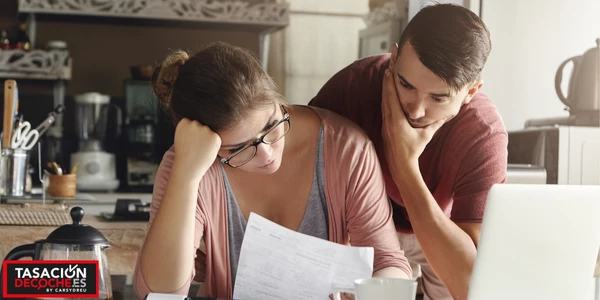 Pareja viendo el contrato de venta de un coche