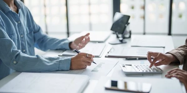 Personas conversando en una mesa con papeles